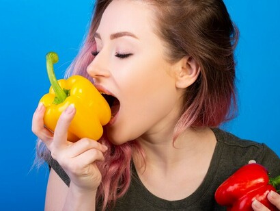 A woman evaluating fresh broccoli and colorful peppers—staples of the Mediterranean diet—promoting a balanced gut-brain axis and contributing to optimal gut flora for improved mental health through nutritional psychiatry