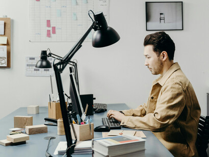 A professional architect developing a 3D design on a computer in a business setting