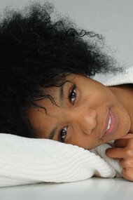 A woman laying down and proudly displaying her culture and heritage with her black hairstyle