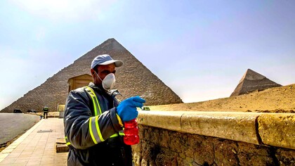 Un trabajador desinfecta el entorno de las pirámides en Egipto