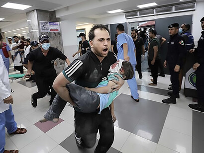 Medics transport an injured Palestinian child into Al-Shifa hospital in Gaza City following an Israeli airstrike on October 11, 2023