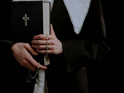 Hands firmly holding a Bible and rosary, representing a steadfast commitment to God's Word amid life's distractions