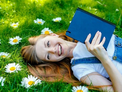 Una joven leyendo entre flores