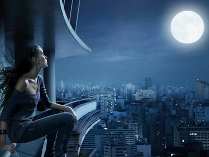 Una joven contempla la luna llena desde su balcón