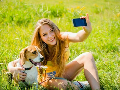 Una adolescente se hace una foto con su teléfono junto a su perro