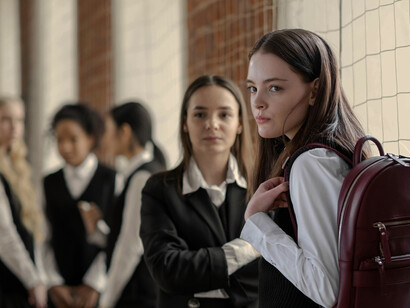 Students in school uniforms socializing in a school basketball court