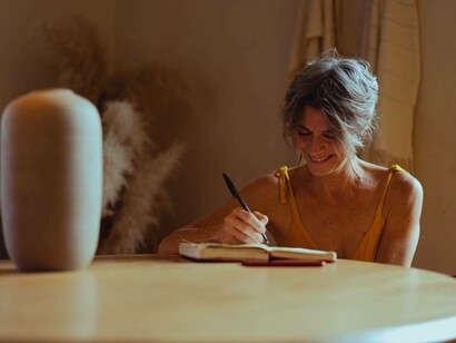 A woman writes in her journal things she does best