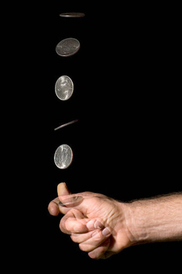 A coin flipped in mid-air, reflecting the precarious choices facing humanity