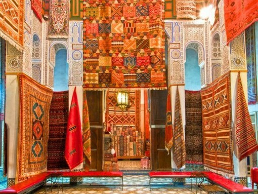 Moroccan rugs brightening historic Fez architecture, reflecting the city’s enduring cultural vibrancy