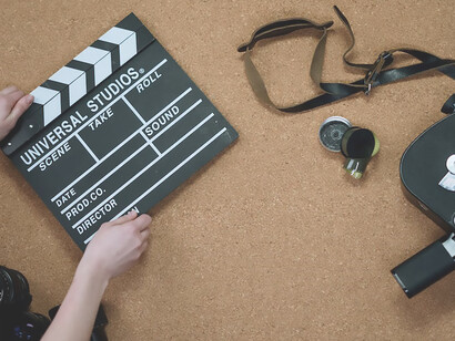 Camera lenses, camera and cinema clapperboard on backdrop