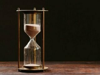 Ampulheta. O relógio era seu algoz, ticando incessantemente, um lembrete do que ainda precisava ser feito