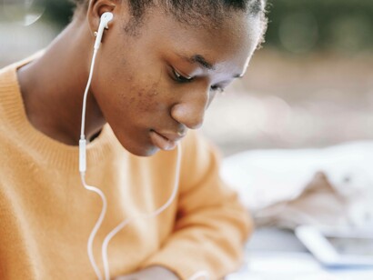 A woman listens and focuses on the discussion taking place in a mental health podcast episode