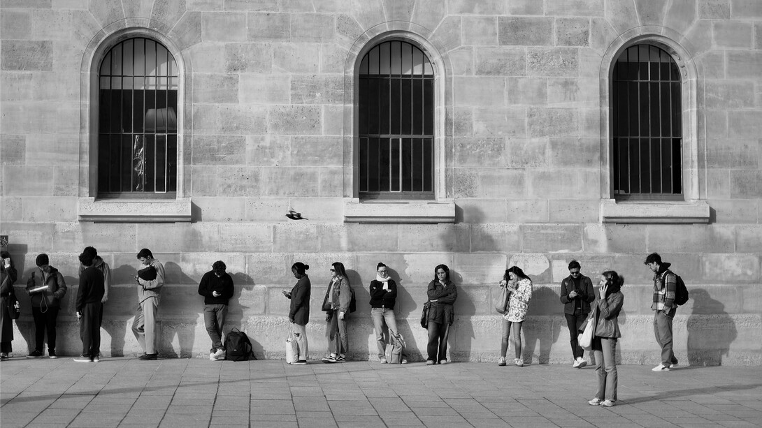 People standing outside a public office with no visible progress, showing the hidden economic cost of lost time