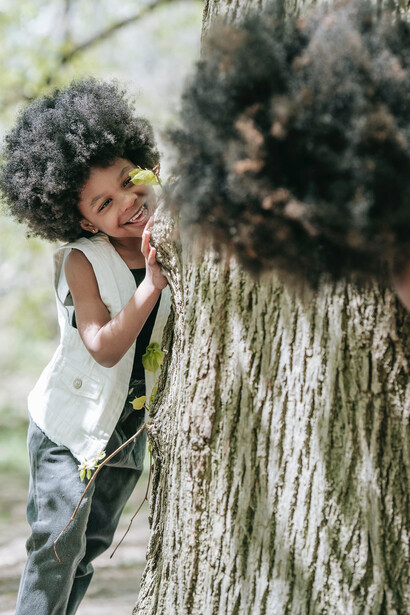 Mãe e filha brincam de esconde-esconde em um parque