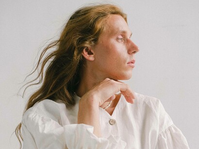 A transgender man posing for the camera with hand underneath chin