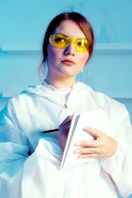 Uma mulher cientista vestindo jaleco enquanto segura um caderno
