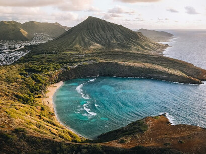 The breathtaking beauty of Oahu, Hawaii, with an aerial view capturing the majestic mountains and serene ocean, showcasing the island's stunning natural landscapes