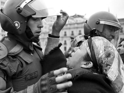 Una mujer mapuche en gesto de dolor ante antidisturbios chilenos