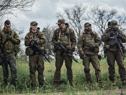 A squad of soldiers in uniform, carrying rifles in hand