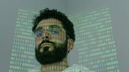 A man with computer code shone over his face 