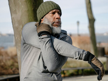 An older Black man working out in a park in autumn, staying active and healthy