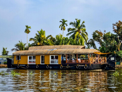 A traditional Kerala houseboat passing through the backwaters in Alappuzha, Kerala, representing how water continues to connect communities across the region