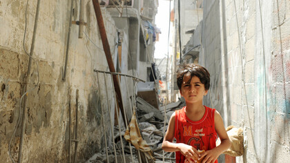 In the shadow of destruction, a child's resilience shines through, reminding us that hope persists even amidst chaos and despair