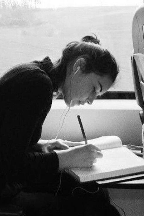 A woman writing in her journal on the train