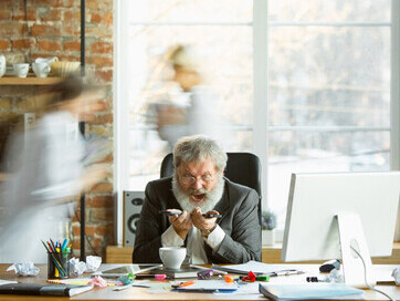 A fatigued and anxious boss is absorbed in work as blurred figures of stressed employees rush by, underscoring the widespread anxiety, conflict, and burnout in the office