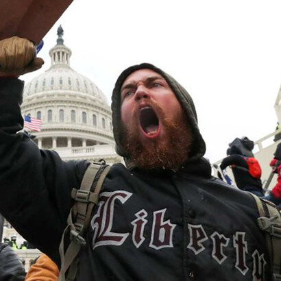 Simpatizante de Trump armado con una tabla durante el asalto al Capitolio; su sudadera lleva la leyenda «Libertad»
