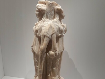 Representação de Hécate, a deusa grega da magia, bruxaria, noite, lua, fantasmas e encruzilhadas. Sua presença inspira terapeutas e estudiosos do imaginário: Hécate é metáfora da travessia psíquica, do processo de encarar o inconsciente e emergir transformado. Ela ensina que todo renascimento exige descida ao abismo, que cada escolha consciente é ato de alquimia interior