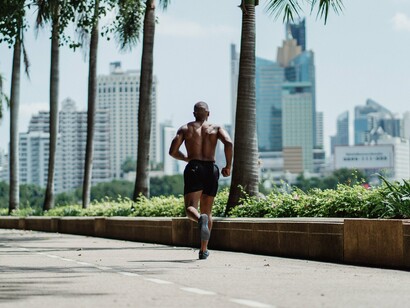 A runner maintaining a steady pace through an urban landscape, symbolising the heart-strengthening benefits of daily exercise