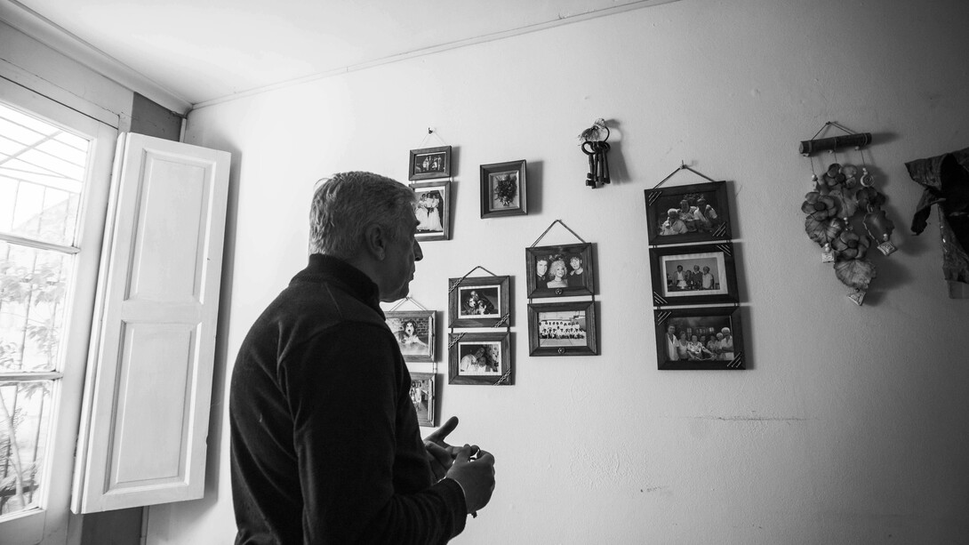 Man reflecting on family memories in a black-and-white photograph