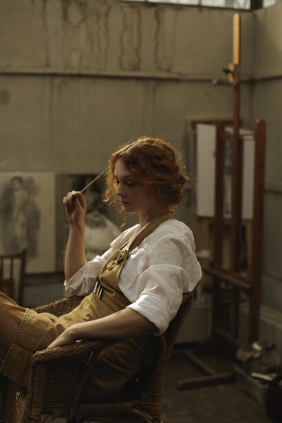 An artist sat in her studio with a paintbrush