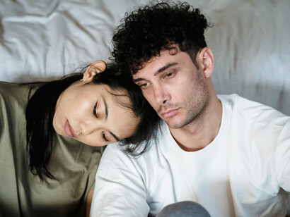 A couple sitting together, appearing worried and distressed