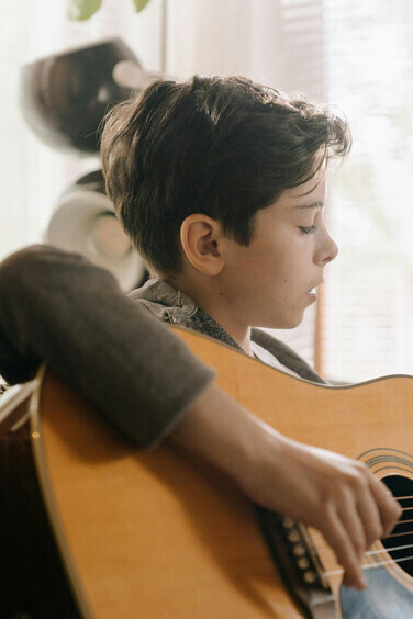 Reviva a nostalgia ao contemplar um garoto habilidoso com sua guitarra, evocando lembranças afetivas e a simplicidade dos tempos passados