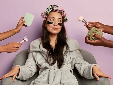A woman relaxing in a spa robe with under-eye patches, reflecting beauty standards shaped by social media filters and cosmetic trends