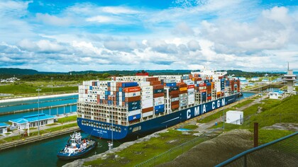 A vast cargo ship passing through the Panama Canal, representing the strategic importance of maritime trade and regional waterways