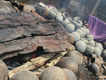 Vasijas de greda y barro colocadas alrededor de un fuego ardiente