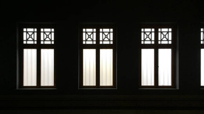 Stanza vuota con finestre alte dalle quali filtra una luca bianca 