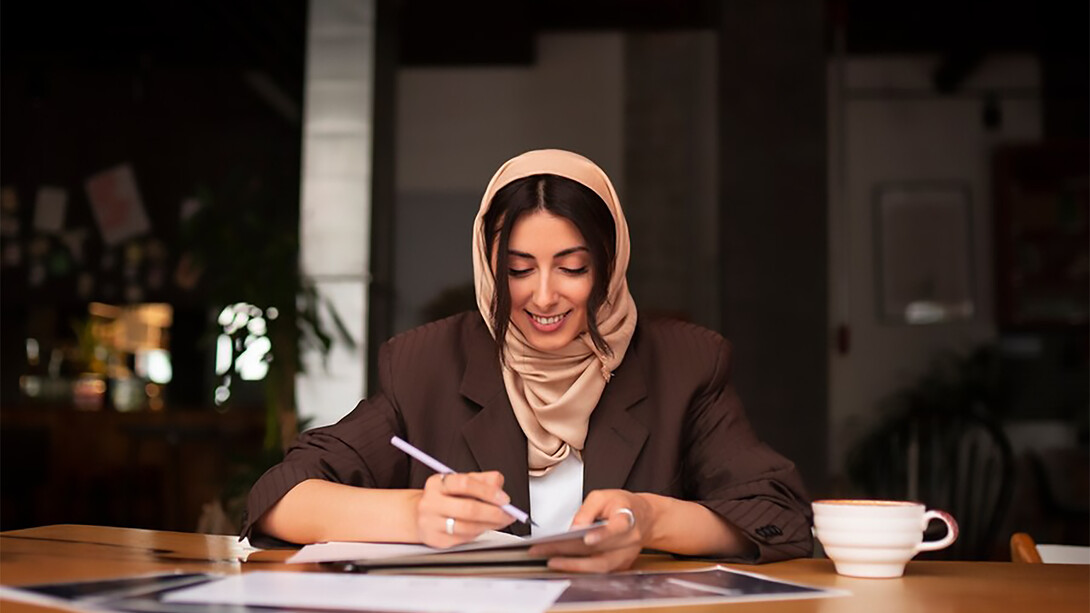 A Pakistani woman in a hijab working indoors in the finance sector