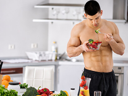 Bodybuilder enjoying a nutritious vegan meal in the kitchen as part of a healthy fitness lifestyle
