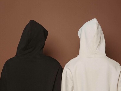 Two people wearing black and white hoodies with their backs toward the camera