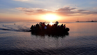Syrian migrants in an overcrowded dinghy from Turkey arrive on the Greek island of Kos
