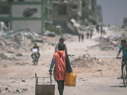 Destruição em Gaza em 2024, com edifícios reduzidos a escombros após bombardeios, enquanto pessoas lutam para sobreviver em meio às ruínas