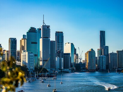 Sailboats scattered across the Brisbane River, symbolising the simple beauty that keeps pulling the author back to the city