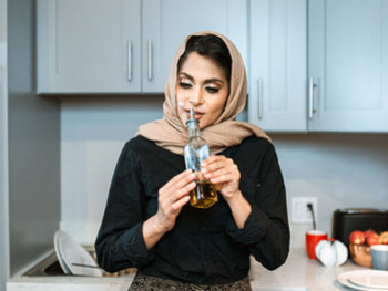 Cozinheira sente o aroma do azeite