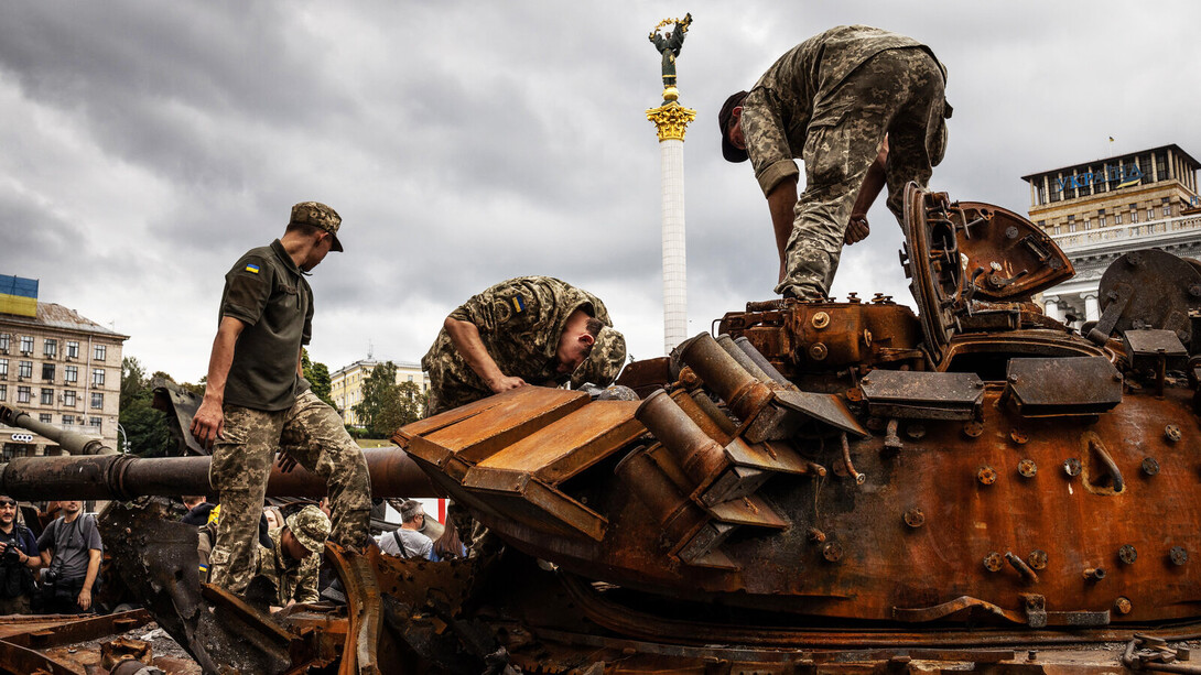 Soldados ucranianos revisando un tanque destruido en Kiev, Ucrania