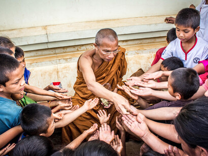 Monge Tibetano reune crianças em praça para alimentá-las com sementes e castanhas