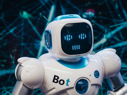 A white and blue humanoid robot, representing artificial intelligence, stands in a futuristic setting